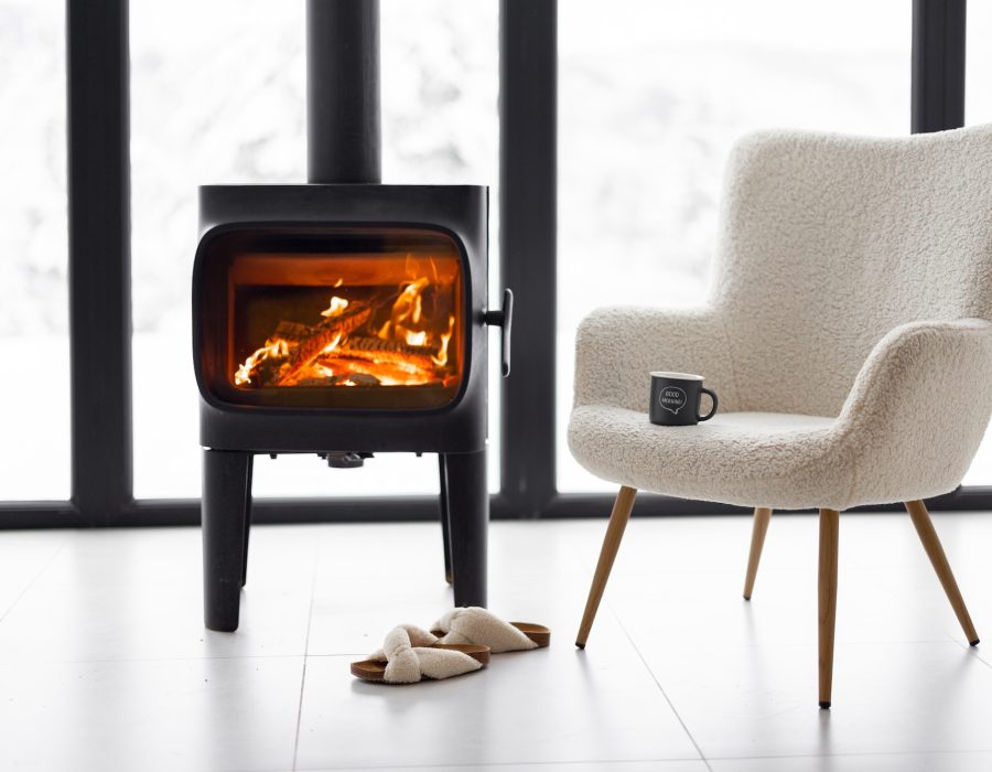 Cozy living space by the burning fireplace at snowy mountains