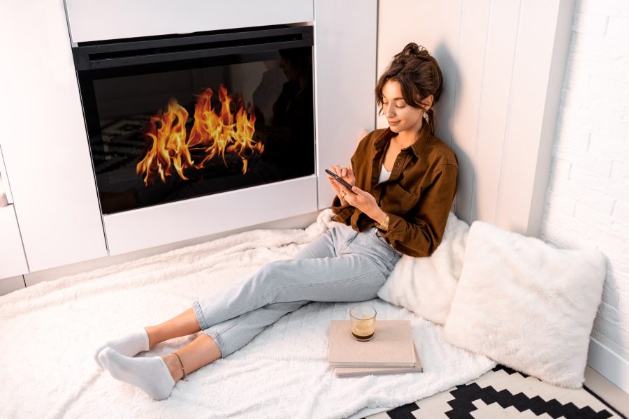 Woman relaxing near the fireplace at home